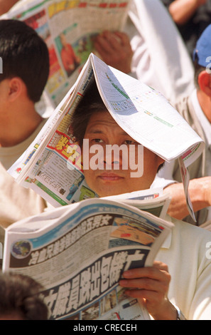 Audience reading the newspaper at the racetrack, Hong Kong Stock Photo