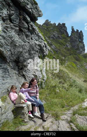mother and two children sit on a bench near Salcombe harbour at bolt head on the south west coast path south devon england Stock Photo