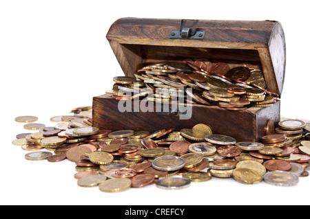 Treasure box on a heap of coins isolated on white background Stock Photo