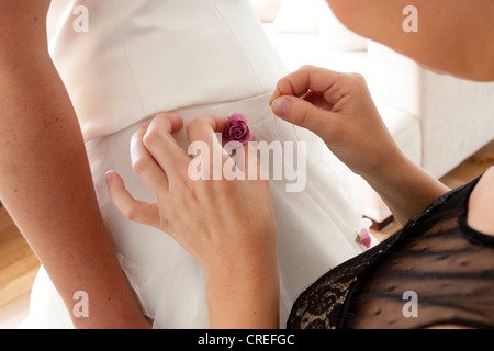 Flower being sewed on a wedding dress Stock Photo