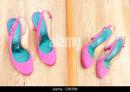 Bridal shoes standing in front of a mirror on parquet flooring Stock Photo