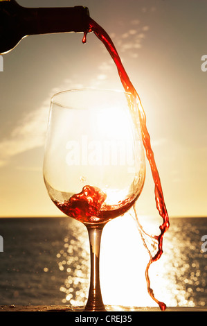 Wine spilling from bottle outdoors Stock Photo