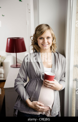 Pregnant woman having cup of coffee Stock Photo