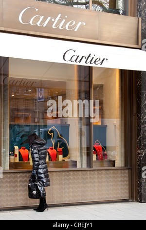 Woman looking at the display in the shopwindow of the Cartier jewelry store, Koenigsallee shopping promenade, short Koe Stock Photo