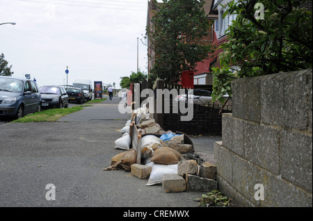 Sandbags and rubble outside properties in Littlehampton East Sussex to protect from flooding UK Stock Photo
