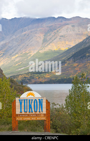 Yukon Territory welcome sign, South Klondike Highway, Indian summer, leaves in fall colours, autumn, Tagish Lake behind Stock Photo