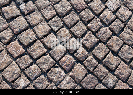 Closeup view on a cobblestone road - pattern - background - contrasty due to a side sunlight Stock Photo