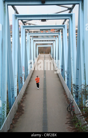 Jogger on a footbrige, Germany, North Rhine-Westphalia, Media-Park, Koeln Stock Photo