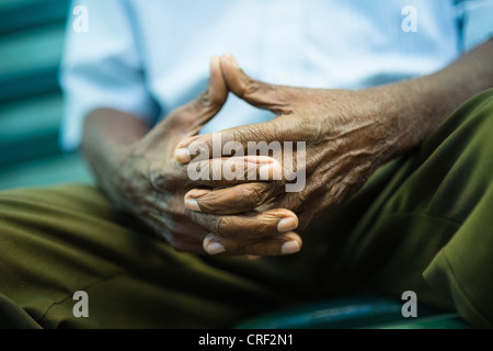closeup of hands of elderly african american man sitting on bench Stock Photo