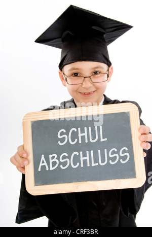 symbolic for school graduation. Small boy as diploma holder with a blackboard Stock Photo