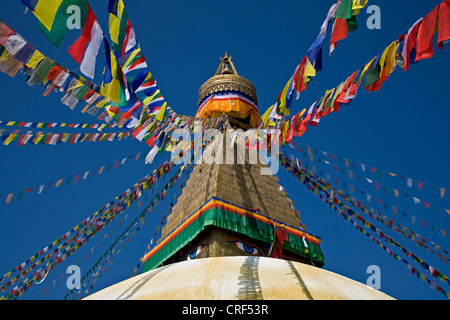 TIBETAN BUDDHIST PRAYER FLAGS fly from the top of BODHANATH STUPA, Nepal, Kathmandu Stock Photo