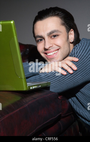 Portrait of cheerful young man using laptop Stock Photo