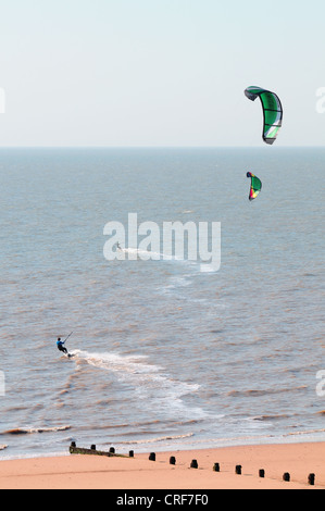 Two men, kite surfing off the beach in Frinton in Essex, early morning Stock Photo
