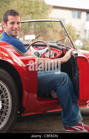 Portrait of a handsome young man in red car Stock Photo