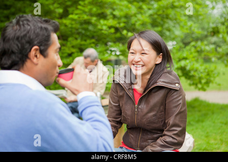 Couple having coffee in park Stock Photo
