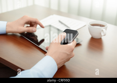 Businessman working with modern mobility devices at the office workplace. Stock Photo