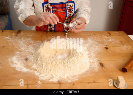 Older woman baking on wooden board Stock Photo