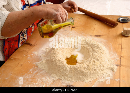 Older woman baking on wooden board Stock Photo