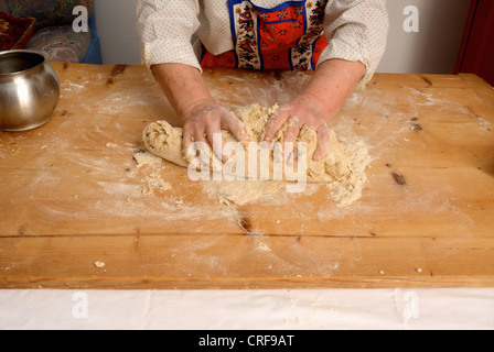 Older woman kneading dough on board Stock Photo