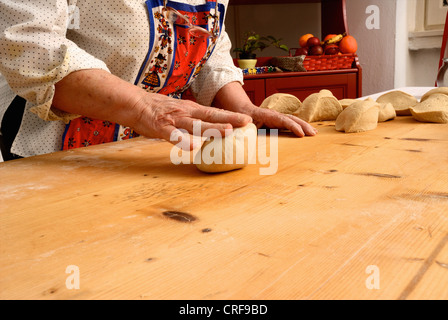 Older woman rolling dough on board Stock Photo