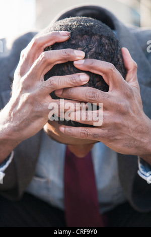 Disappointed businessman with head in hands Stock Photo