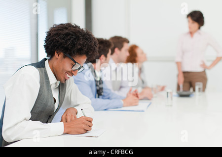 Businessman making notes in meeting Stock Photo