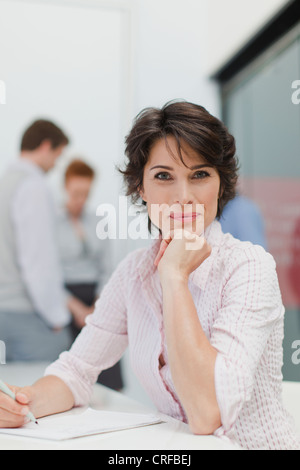 Businesswoman making notes in meeting Stock Photo