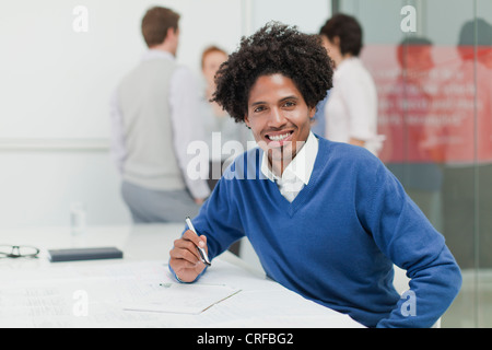 Businessman making notes in meeting Stock Photo