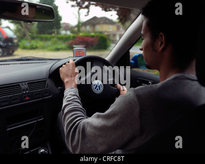 Afro-Caribbean Man Driving Car Using Tom Tom Satellite Navigation System England Stock Photo