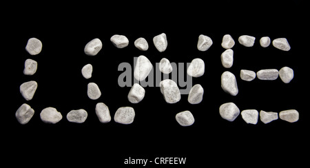 love in white stones on black background