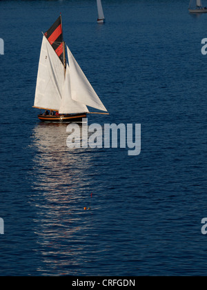 Early evening sun reflecting on white sails of a yacht, Falmouth, Cornwall, UK Stock Photo