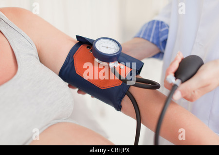 Doctor taking womans blood pressure Stock Photo