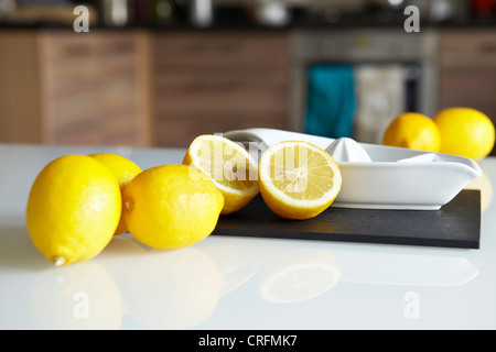 Lemons and juicer on kitchen counter Stock Photo