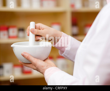 Pharmacist using mortar and pestle Stock Photo