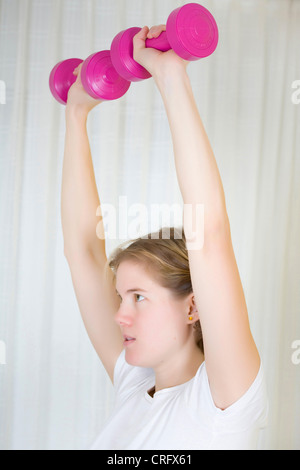 young woman doing exercise with dumb-bells Stock Photo