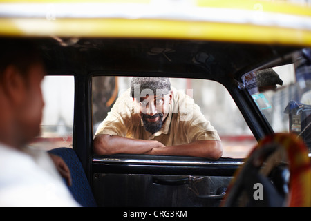 Smiling man leaning in taxi cab window Stock Photo
