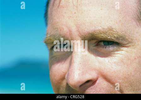 A close up of a man's face on beach in extreme sunlight. Stock Photo