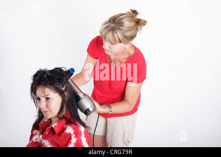 woman at hairdresser, drying and styling the wet hair Stock Photo