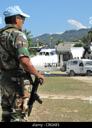 soldier of the 'United Nations Stabilisation Mission in Haiti' secures UN aircraft with machine gun on unpaved runway, Haiti, Grande Anse, Jeremie Stock Photo