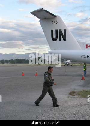 Pilot in battle dress passes aircraft of the 'United Nations Stabilisation Mission in Haiti', Haiti, Provine de l'Ouest, Port-Au-Prince Stock Photo