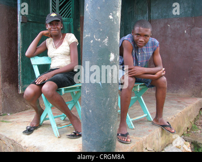 Boy and girl sitting in front of a house, Haiti, Grande Anse, Dame Marie Stock Photo