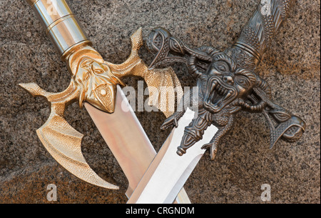 Medieval design  crossed sword handles & blades with demons closeup Stock Photo