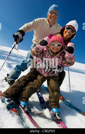 family on ski has fun in the snow; man, woman and child wearing caps and sunglasses, France, Alps Stock Photo