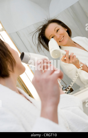 young woman in bath drying her hair Stock Photo