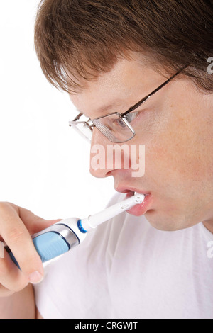 man brushing teeth with electric toothbrush Stock Photo