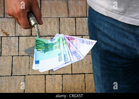 symbolic image building costs: bills and trowel Stock Photo