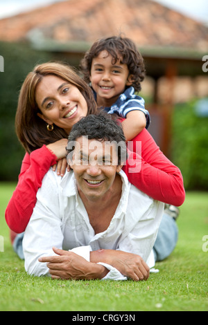 parents and son lying upon each other in meadow Stock Photo