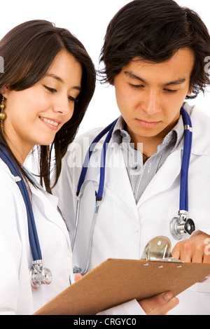 two young doctors with stethoscopes, looking at a clamp board Stock Photo