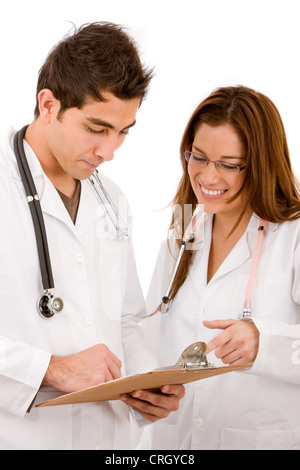 two young doctors with stethoscopes, looking at a clamp board Stock Photo