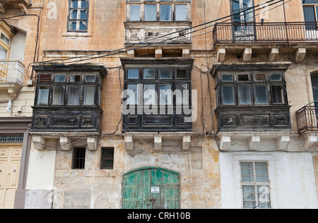 Ornate enclosed wooden balconies (gallarija, gallariji) are a traditional feature on many old houses in Valletta, Malta Stock Photo